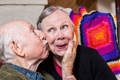 Elderly Gentleman Kissing Elderly Woman on Cheek