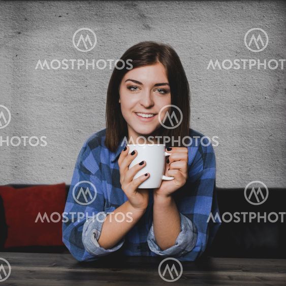 Young woman sitting at a table with a coffee mug