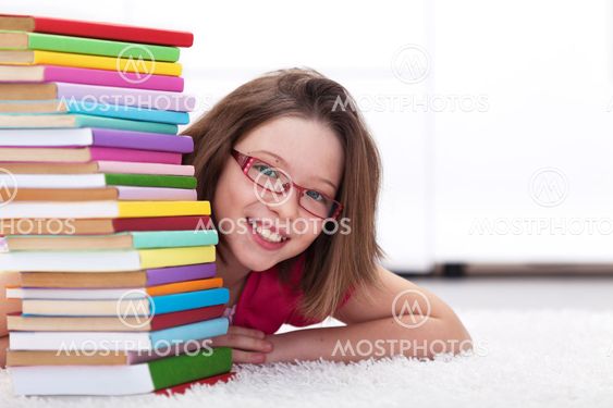 Young student with lots of books smiling