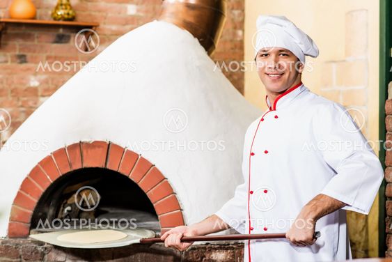 Chef puts dough in the oven for pizzas,