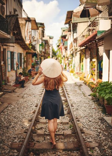 Walking, travel and back of woman by train tracks with...