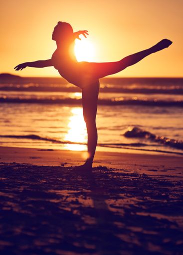 Woman, sunset and dancing silhouette on seashore,...