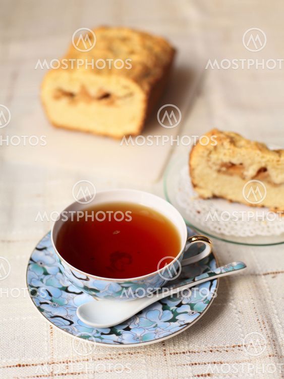 Teacup with slice of a delicious cake on a table