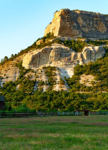 Stunning rocky cliff with lush greenery at the base...