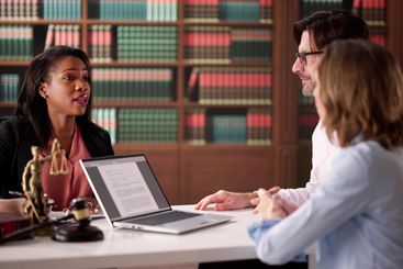 Professional Couple and Lawyer Reviewing Divorce Contract