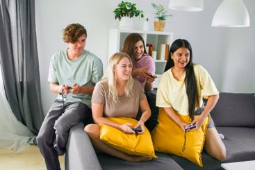 Cheerful group of friends playing video games together...