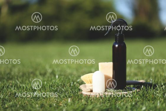 Spray bottle on the wooden plate with brush and soap
