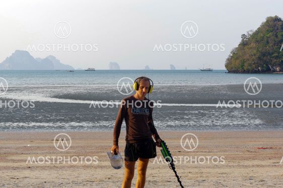 Treasure hunter with Metal detector on the beach