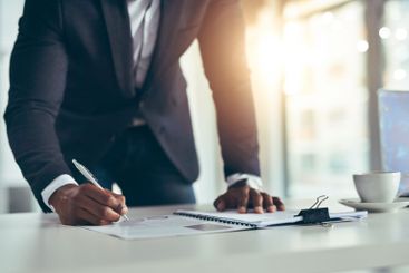 Businessman, writing and documents with policy at office...