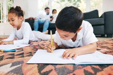 Children, siblings and coloring homework in home,...