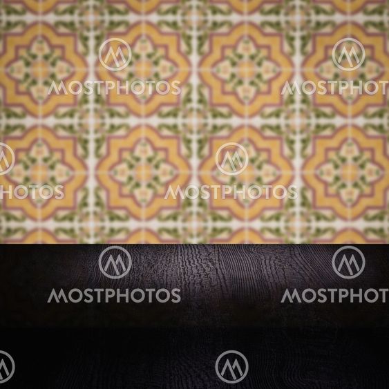 Wood table top and blur vintage ceramic tile pattern wall
