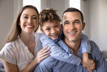 Happy couple of parents and son child sitting close...