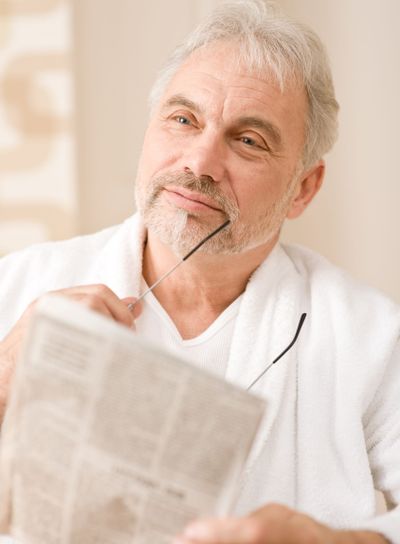 Senior mature man thoughtful read newspaper