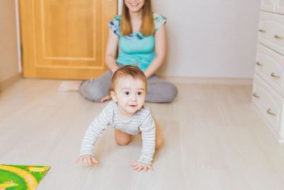 Happy crawling baby boy with mother