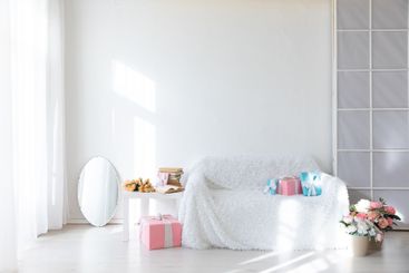 White sofa with holiday gifts and flowers in the...
