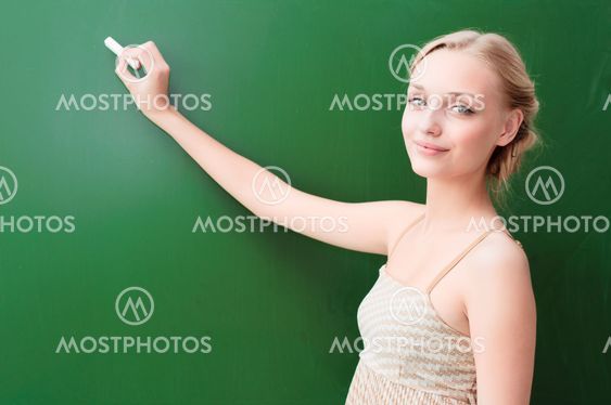 teacher writes on the blackboard with chalk