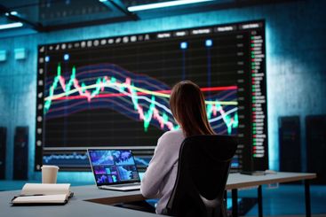 Analyzing Stock Data on Computer Screen: Businesswoman