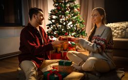 happy couple with christmas gift at home