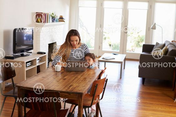 Mother And Daughter Using Laptop At Home Together