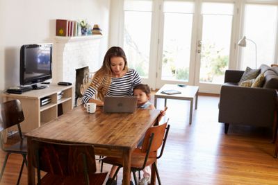 Mother And Daughter Using Laptop At Home Together