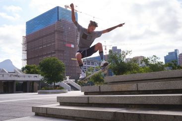 Skateboard, jump and stairs with man in city for...