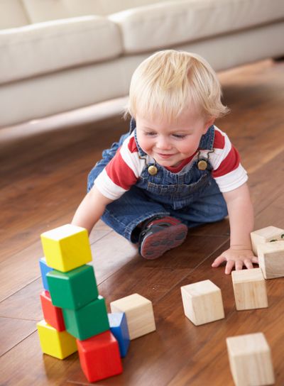 Young Boy Playing With Coloured Blocks At Home