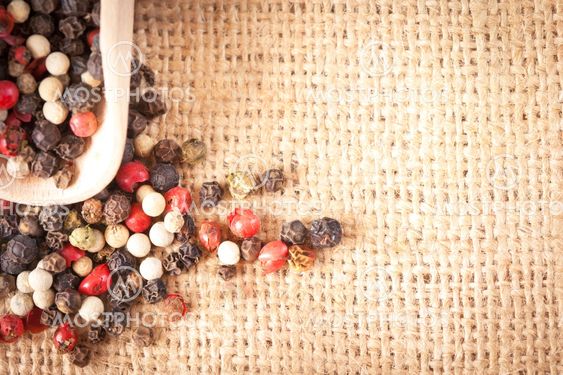 Red, white and black pepper in a spoon