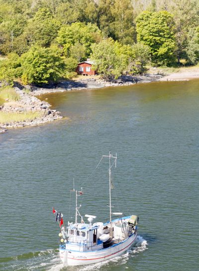 Small fishing boat on the blue sea heading back after...