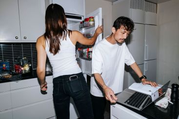 Young man using studying through laptop while female...