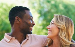 Couple Smiling at Each Other in Natural Setting During...