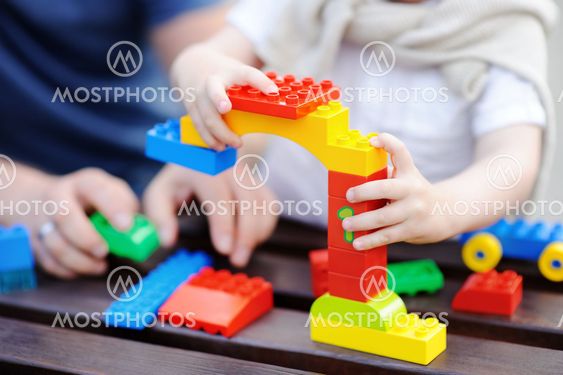 Father with his toddler son playing with colorful plastic...