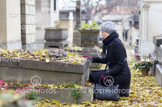 Solitary woman visiting relatives grave.
