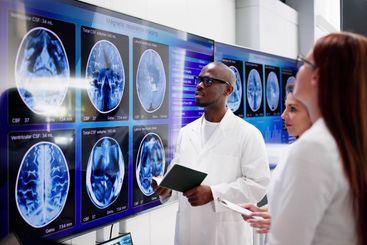 Doctors In Clinic Looking At Brain MRI Scan