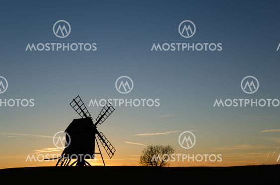 Old windmill silhouette by sunset
