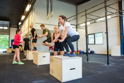 Athletes Doing Box Jumps At Gym