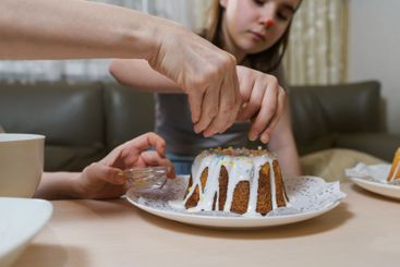 Mother and daughter decorating Easter cakes together.