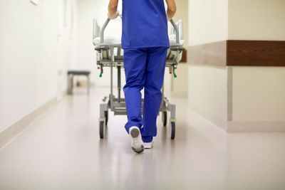 nurse carrying hospital gurney to emergency room