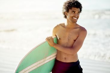 Thinking, man and surfing with smile at beach, sea and...