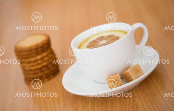 Cup of black tea with lemon, sugar and biscuits