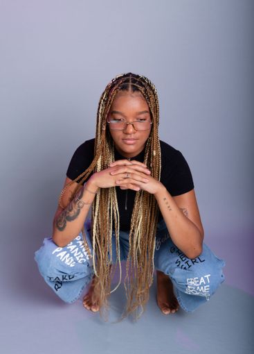 Brunette model with braids in her hair, wearing...