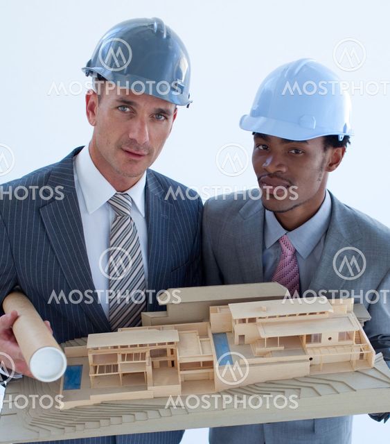 Close-up of architects holding a model house in office