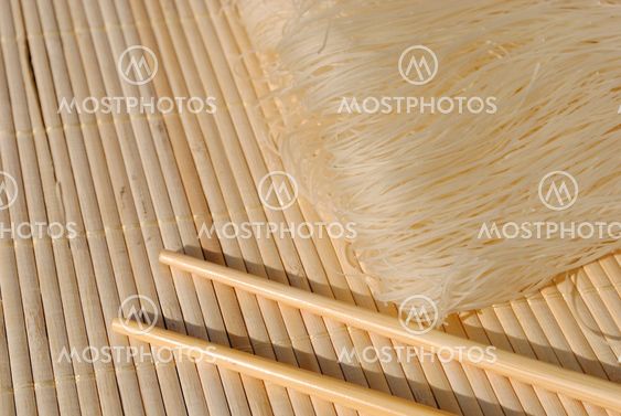 rice needles on a bamboo place mat with chopsticks