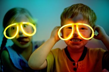 Night, kids and neon glasses in home for fun, playing...