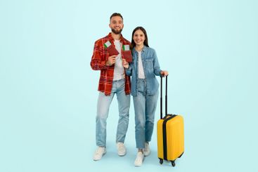 Cheerful caucasian travelers couple standing with...