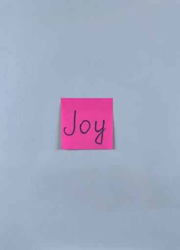 Sticky note with the word Joy written on it, placed on...