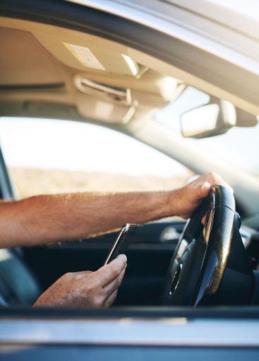 Hands, phone and driving car with search on road trip,...