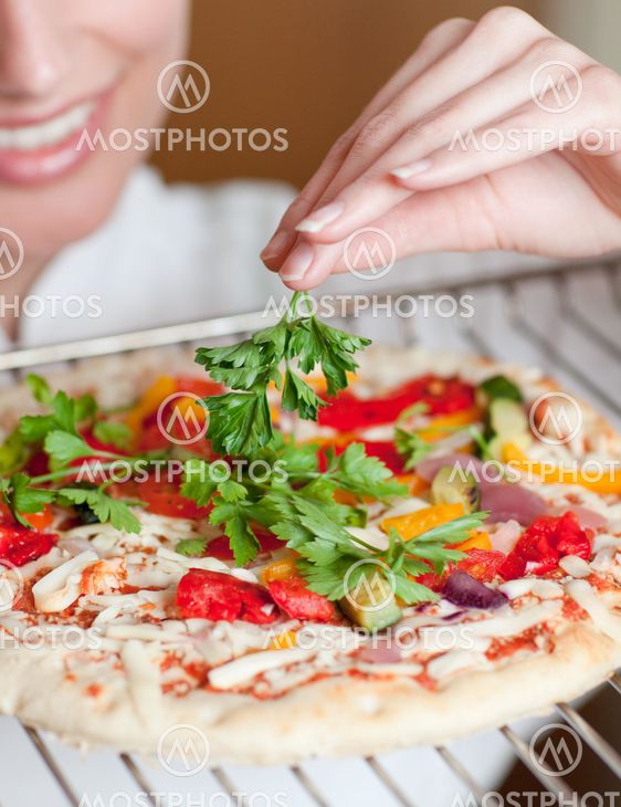 Close-up of a female chef preparing a pizza