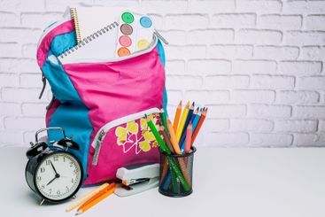 Colorful backpack with school supplies and an alarm...