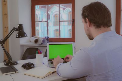 man typing on laptop green screen