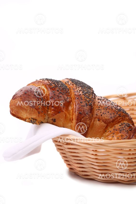 Appetizing croissants with poppy in basket.